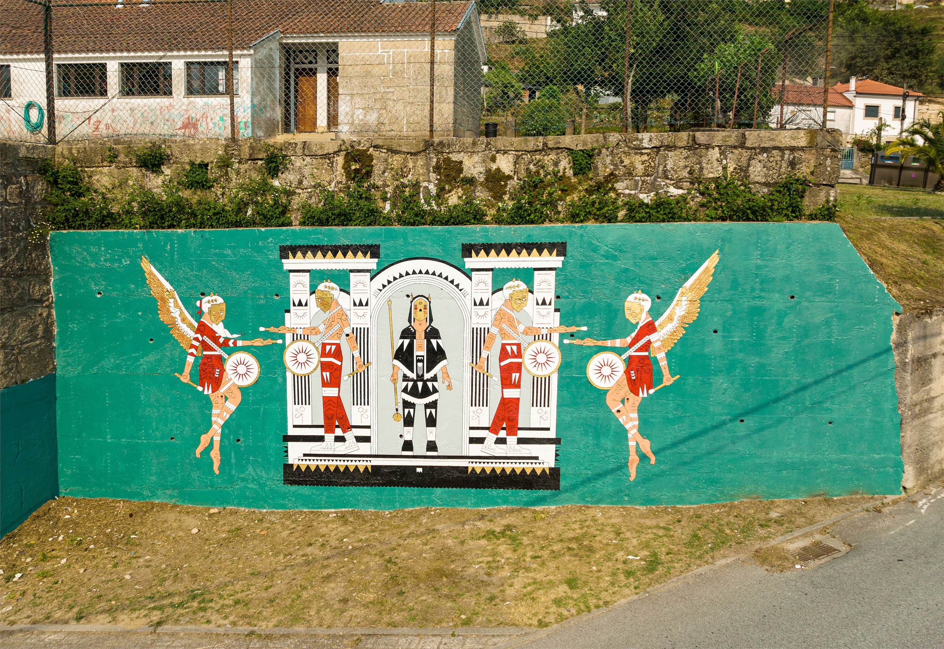 14.07.2022
Inspirada no Carnaval de Vilarinho, a obra tenta transportar para a parede os sons e as sensações vividas no mesmo. O som e a energia dos bombos, que ecoam pela freguesia à medida que o cortejo avança pelas ruas, têm um grande destaque na obra, pois é no som dos mesmos que é gerada toda a energia e vibração contagiosa do Carnaval de Vilarinho. No centro a representação de um Careto, conhecidos por serem uns “diabretes” durante o Carnaval, pois são eles os reis das partidas e das traquinices, sendo também o som dos bombos o aviso da sua chegada.